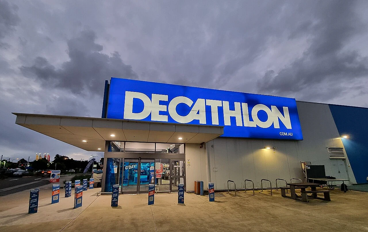Decathlon mağaza dış görünümü Decathlon mağazasının dış cephesi, büyük mavi tabela ve giriş alanı görünümü.