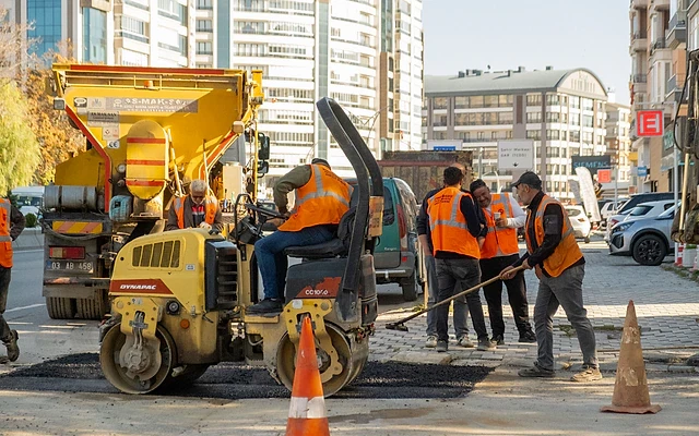 Gazaltı kaynakçısı arayan firmalar için iş fırsatları Şantiyede çalışan işçiler, inşaat araçları ve binalar arasında iş yapıyor.