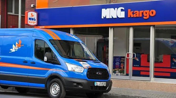 MNG Kargo maaşları hakkında detaylı bilgi MNG Kargo şubesinin önünde mavi bir kargo aracı, işletmenin logosu görünmekte.
