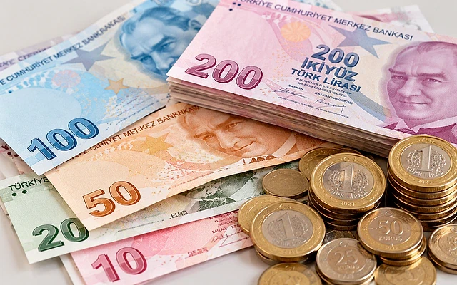 Maaş biriktirme yolları ve tasarruf ipuçları Türk Lirası banknotları ve madeni paralar bir arada, tasarruf ve birikim simgesi.