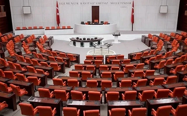 Türkiye Büyük Millet Meclisi iç mekanı Türkiye Büyük Millet Meclisi'nin iç mekan görünümü, boş sandalye ve masalarla düzenlenmiş.